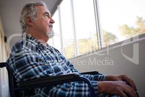 Low angle view of thoughtful senior man sitting on wheelchair
