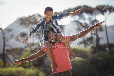 Happy father carrying son on shoulders