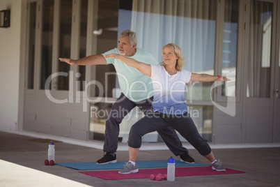 Senior couple performing stretching exercise