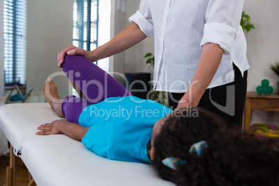 Physiotherapist giving leg massage to a girl patient