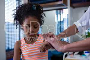 Physiotherapist giving hand massage to a girl