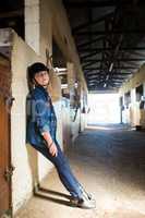 Girl leaning on wall in the stable