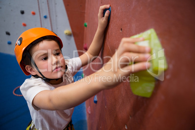 Determined boy practicing rock climbing