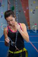 Woman preparing for rock climbing in fitness studio