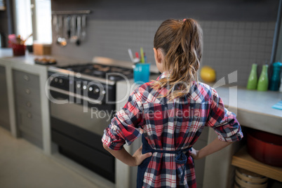 Smiling girl posing wearing an apron in the kitchen