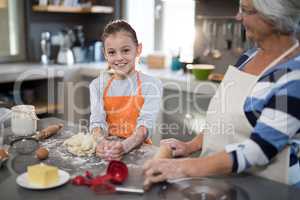 Granddaughter posing while kneading dough in the kitchen