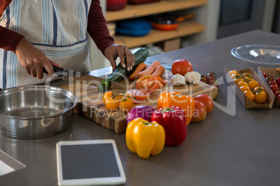 Mid section of woman cutting zucchini