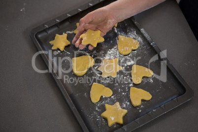 Cropped hand keeping star shape cookie in tray