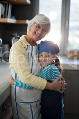 Grandmother and granddaughter embracing in the kitchen