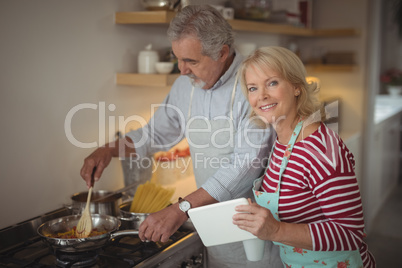 Senior couple preparing food in kitchen