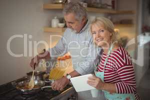 Senior couple preparing food in kitchen