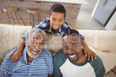 Smiling multi-generation family sitting together on sofa