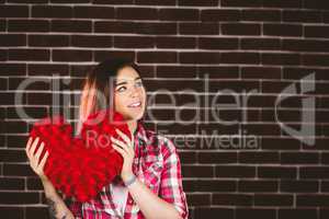 Thoughtful woman holding heart shape