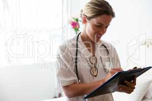 Female doctor examining reports in retirement home