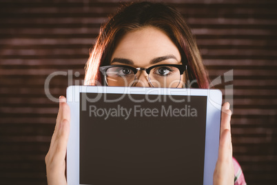 Portrait of woman hiding face from digital tablet