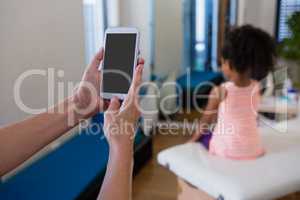 Hand of physiotherapist using mobile phone