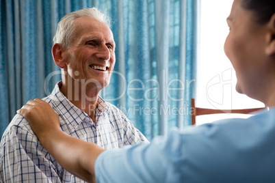 Senior man talking to female doctor in retirement home