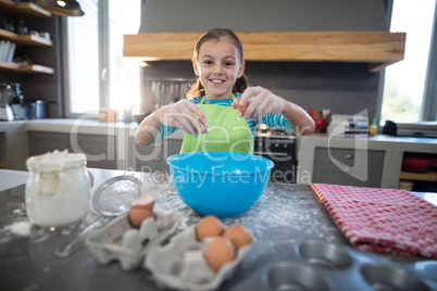 Smiling girl breaking egg
