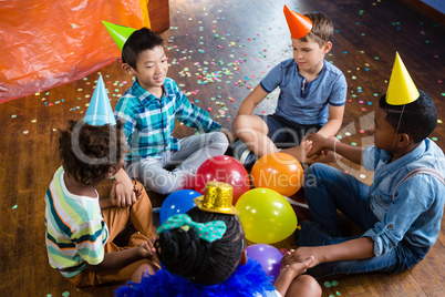 High angle view of children sitting with holding hands