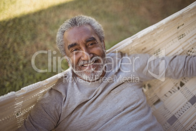Smiling senior man relaxing on hammock