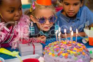 Close up of children looking at birthday cake