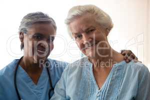 Portrait of smiling nurse and senior woman in nursing home