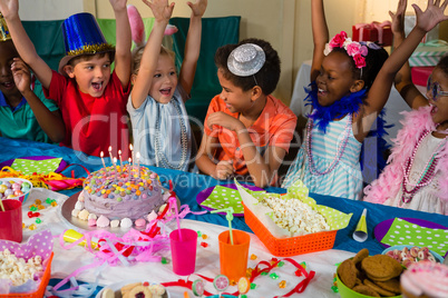 Cheerful children with arms raised