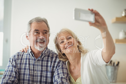 Senior couple taking a selfie in the kitchen Senior couple taking a selfie in the kitchen