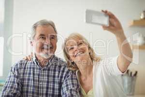 Senior couple taking a selfie in the kitchen