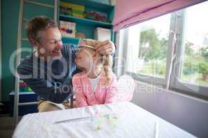 Father putting a tiera on daughters head
