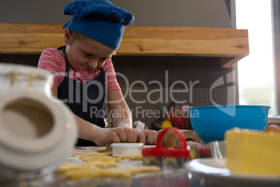 Boy preparing cookies in kitchen