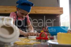 Boy preparing cookies in kitchen