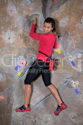 Portrait of confident woman practicing rock climbing