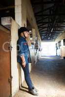 Girl leaning on wall in the stable