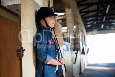 Girl leaning on wall in the stable