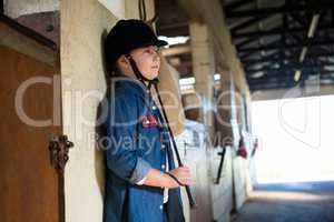 Girl leaning on wall in the stable