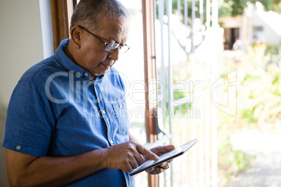 Senior man using digital tablet at nursing home