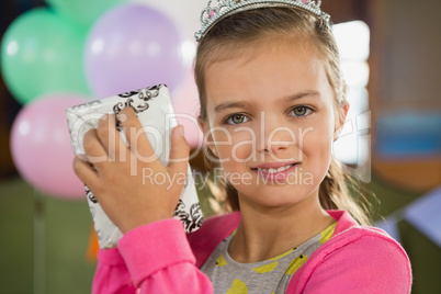 Birthday girl holding a gift box at home