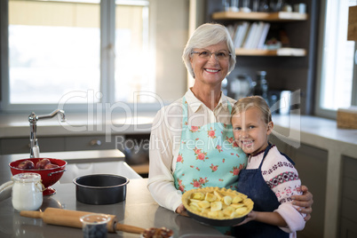 Grandmother and granddaughter posing with fresh cut apples on crust