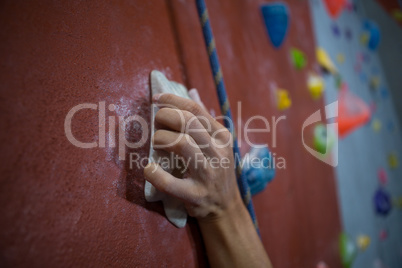 Athlete practicing rock climbing in fitness studio