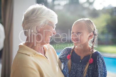 Granddaughter and grandmother smiling together on a sunny day