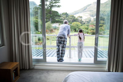 Father and daughter standing together in balcony