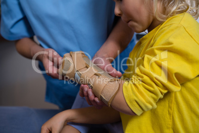 Female physiotherapist giving hand massage to girl patient