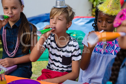 Children blowing part horns