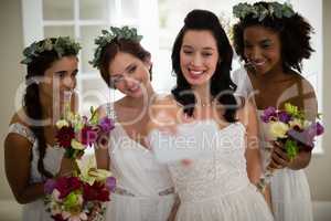 Bride and bridesmaid taking selfie at home