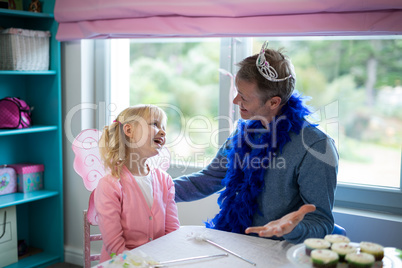 Girl pretending to be a fairy playing with her father