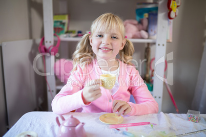 Cute girl having tea while playing with from the toy kitchen set