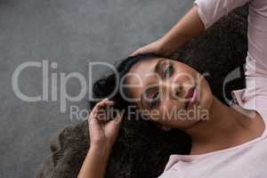 Woman relaxing on bed over floor