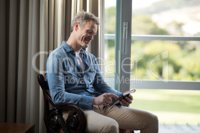 Smiling man using digital tablet on chair Smiling man using digital tablet on chair