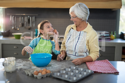 Granddaughter showing eggs to grandmother and smiling